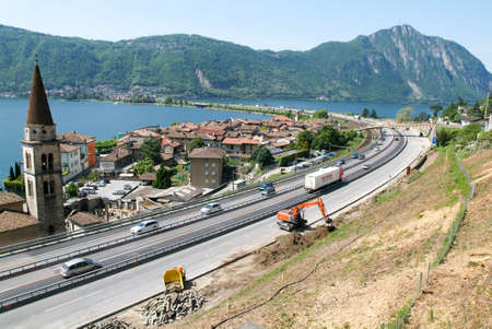 Hydraulic digger breaking up a wall on a highwayのeditorial素材
