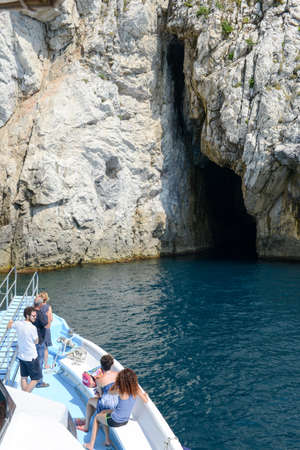 Tino island (Portovenere), Italy - 7 July 2015: Tourists cruising with a boat in front of a cave at Tino island near Portovenere on cinque terre, Italyのeditorial素材