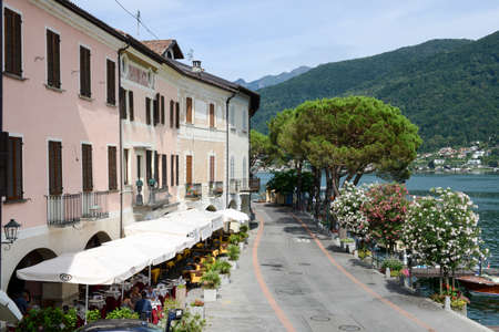 Morcote, Switzerland - 13 July 2015: People eating and drinking on a restaurant at the village of Morcote on lake lugano, Switzerlandのeditorial素材