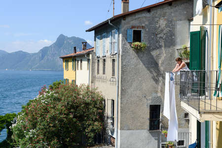 Gandria, Switzerland - 3 August 2015: Woman stretching out the linen on her  terrace in Gandria on Lake Lugano in Switzerlandのeditorial素材