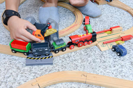 Lugano, Switzerland - 29 August 2015: boy playing with a wooden train set on a gardenの写真素材