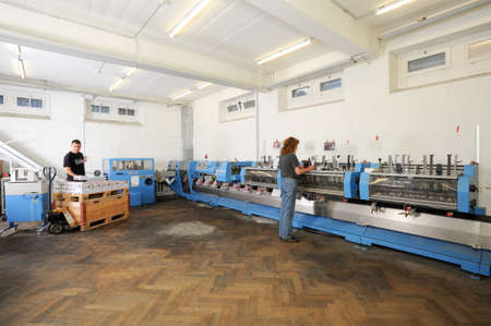 Bern, Switzerland - 19 september 2013: people working on a brochure and magazine stitching process...