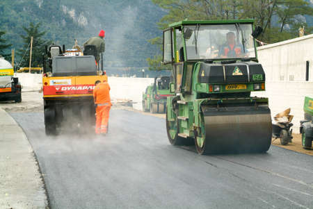 Melide, Switzerland - 23 october 2009: Workers and vehicles during the asphalting of the highway at...