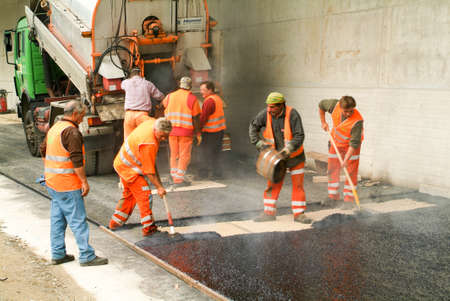 Melide, Switzerland - 23 october 2009: Workers and vehicles during the asphalting of the highway at Melide on Switzerlandのeditorial素材