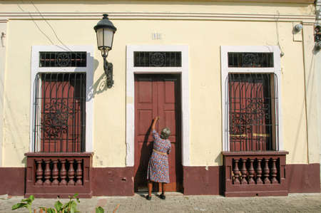 Santo Domingo, Dominican Republic - 3 february 2002: woman opening the entrence door of her colonial house at Santo Domingo on Dominican Republicのeditorial素材