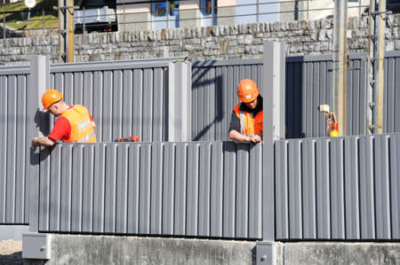 Capolago, Switzerland - 9 march 2012: Workers during the installation of noise barriers on the railway at Capolago on Switzerlandのeditorial素材