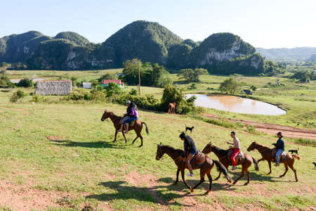 Vinales, Cuba - 25 january 2016: people riding horses in the valley of Vinales on Cubaのeditorial素材
