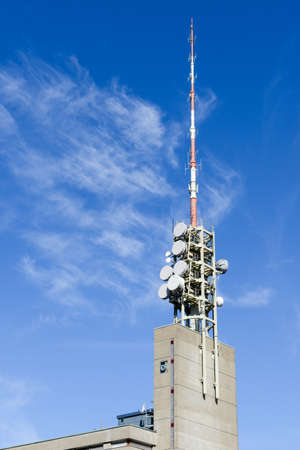 Telecommunication antenna with microwave link antennas over a blue skyの写真素材