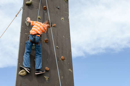 Massagno, Switzerland - 12 June 2016 - Effort of a boy in climbing a wall to reach the topのeditorial素材