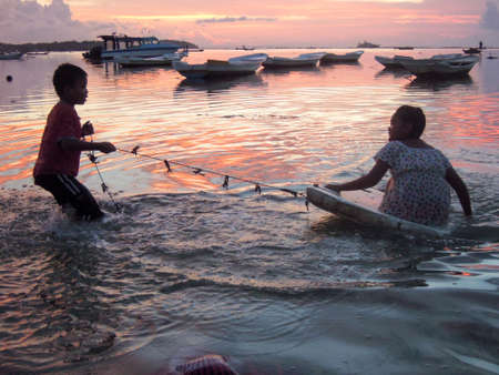 Nusa Lembongan, Indonesia - 13 February 2013: Children playing at the beach on a colorful sunset in Nusa Lembongan, Indonesiaのeditorial素材