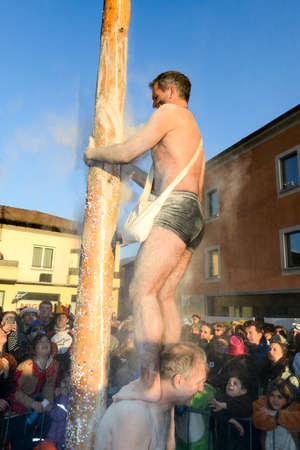 Tesserete, Switzerland - 13 February 2016: men trying to climb the greasy pole of the carnival at Tesserete on the italian part of Switzerlandのeditorial素材