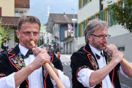 Kerns, Switzerland - 1 October 2016: People wearing traditional clothes and playing the alphorn at Kerns on the Swiss alpsのeditorial素材