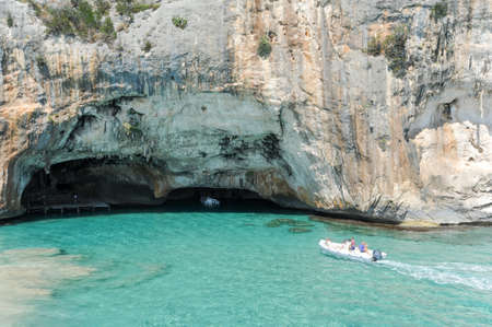 Bue Marino, Italy - 28 June 2013: people on a motorboat visiting the cave of Bue Marino on the island of Sardinia, Italyのeditorial素材
