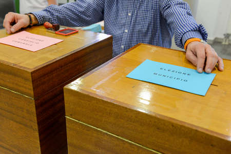 Lugano, Switzerland - 11 april 2016: Hand  validating a voting ballot at the municipal election of...