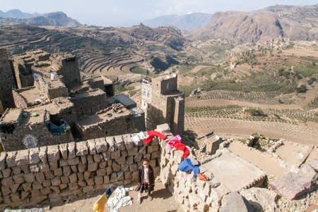 Al Hajjarah, Yemen - 8 january 2016: little girl on the roof of little girl on the roof of his house at the village of Al Hajjarah on Haraz mountains, Yemenのeditorial素材