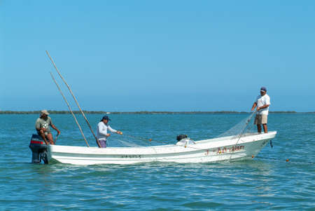 Holbox, Mexico - 29 January 2009: fishermen withdrawing the fishing net from their boat at Holbox island, Mexicoの写真素材