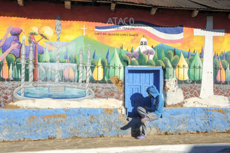 Conception de Ataco, El Salvador, 17 January 2014: Man sitting near a mural at Conception de Ataco on El Salvadorのeditorial素材