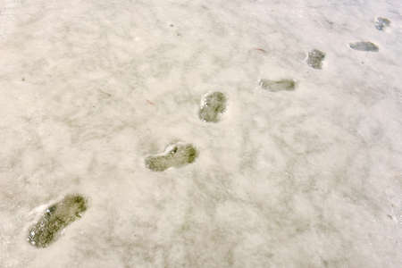 Footprints on a frozen lake on winterの写真素材