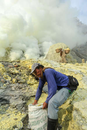 Vulcano Ijen, Indonesia - 5 February 2013: Miners with their sulfur crops climb the ijen crater on the island of Java, Indonesiaのeditorial素材