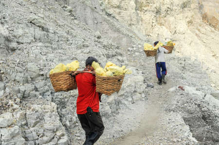 Vulcano Ijen, Indonesia - 5 February 2013: Miners with their sulfur crops climb the ijen crater on the island of Java, Indonesiaのeditorial素材
