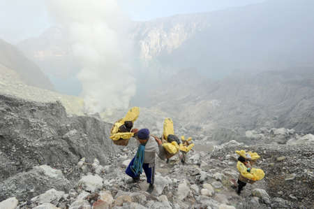 Vulcano Ijen, Indonesia - 5 February 2013: Miners with their sulfur crops climb the ijen crater on the island of Java, Indonesiaのeditorial素材