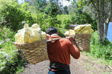 Vulcano Ijen, Indonesia - 5 February 2013: Miner with their sulfur crops from the ijen crater on the island of Java, Indonesiaのeditorial素材