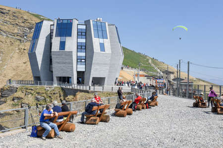 Monte Generoso, Switzerland - 8 April 2017: Tourists walking and  sunbathing in front of the modern restaurant on the summit of Mount Generoso on the Swiss alpsのeditorial素材
