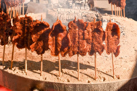 Grilled meat skewers cooked on the fire at street food festival of Lugano on Switzerlandの写真素材