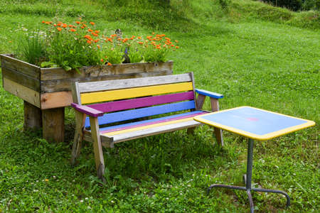Multicolored bench and table in a garden of Engelberg on the Swiss alps