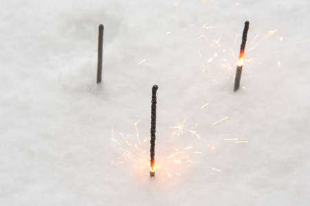 Burning glittering sticks on the snowの写真素材