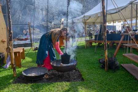 Bellinzona, Switzerland - 27 May 2018: girl cooking at the medieval historical re-enactment on Castelgrande castle at Bellinzona on the Swiss alpsのeditorial素材