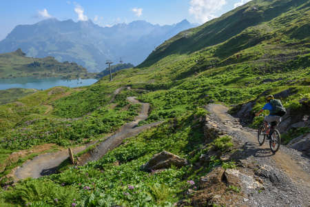 Jochpass, Switzerland - 4 august 2018: boy on his mountain bike going down the path from Jochpass over Engelberg in the Swiss Alpsのeditorial素材