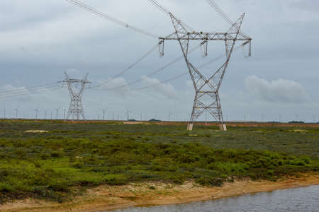 Windmills and electric trellis on a field near Atins on Brazil