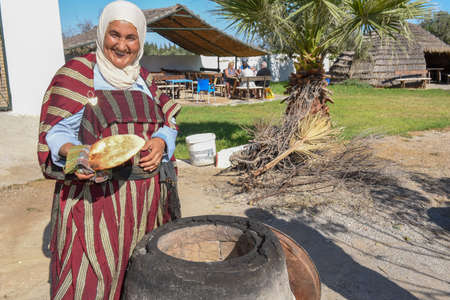 Sousse, Tunisia -  8 November 2019: old lady baking a traditional arab bread at Sousse in Tunisiaのeditorial素材