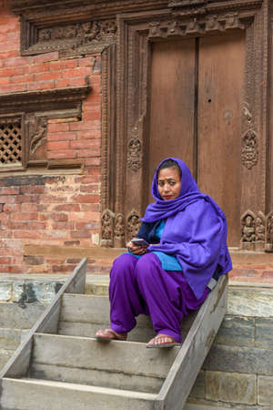 Kathmandu, Nepal - 7 January 2020: woman sitting in front of a temple in Durban square at Kathmandu on Nepalのeditorial素材