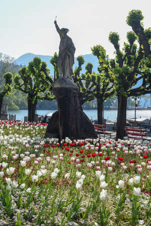 Lugano, Switzerland - 23 April 2020:  Public garden with a statue of Willhelm Tell on the lakefront at Lugano on Switzerlandのeditorial素材