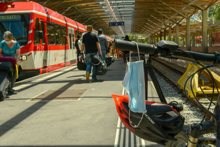 Zermatt, Switzerland - 20 July 2020: mask hanging on the handlebar of a bike in a train stationのeditorial素材