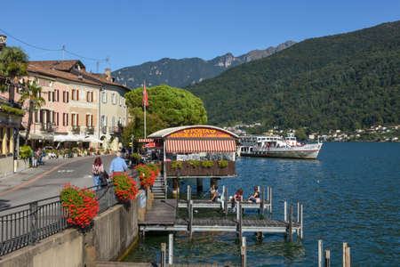 Morcote, Switzerland - 28 September 2020: people eating and drinking on street restaurants of Morcote in Switzerlandのeditorial素材