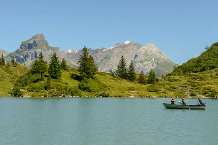 Engelberg, Switzerland - 8 August 2020: tourists rowing in their boat at lake Truebsee above...