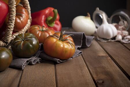 Organic food vegetables in wicker basket on rustic wooden table.の写真素材