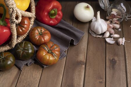 Organic food vegetables in wicker basket on rustic wooden table.の写真素材