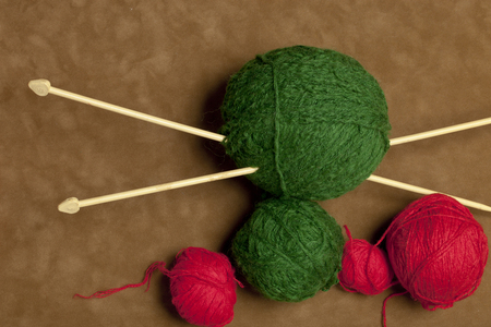 multicolored yarn and knitting needles for knitting on a light background