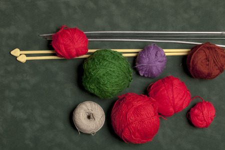 multicolored yarn and knitting needles for knitting on a green backgroundの写真素材