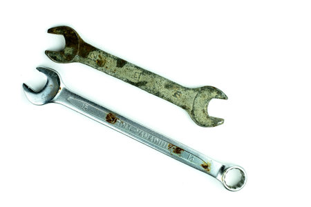 Old wrench, rusty copper and silver wrench isolated on white background, close-up.