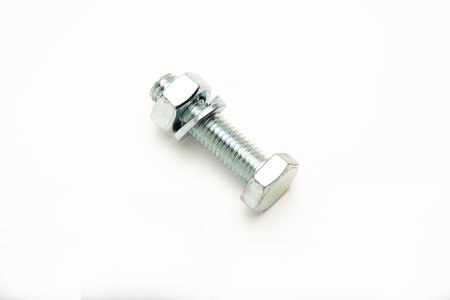 A close-up of a metallic bolt with a nut, showcasing its threaded design and hexagonal head. The...