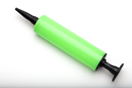A green balloon pump with a black nozzle on a white background. The pump is cylindrical and designed...