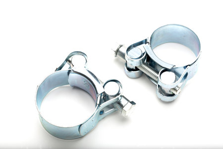 Two metal pipe clamps are displayed on a white background. They are shiny and circular,の写真素材
