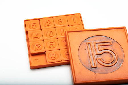 A classic 15-puzzle game with orange tiles. The puzzle consists of numbered squares arranged in a...