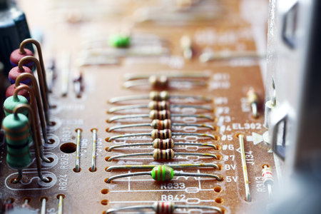 Close-up of a printed circuit board with resistors and capacitors. The board features copper traces and green components, showcasing electronic technology.の写真素材