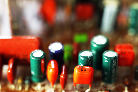 Close-up of electronic components on a circuit board. Various capacitors and resistors in different colors and sizes are visible. Focus on technology and electronics.の写真素材
